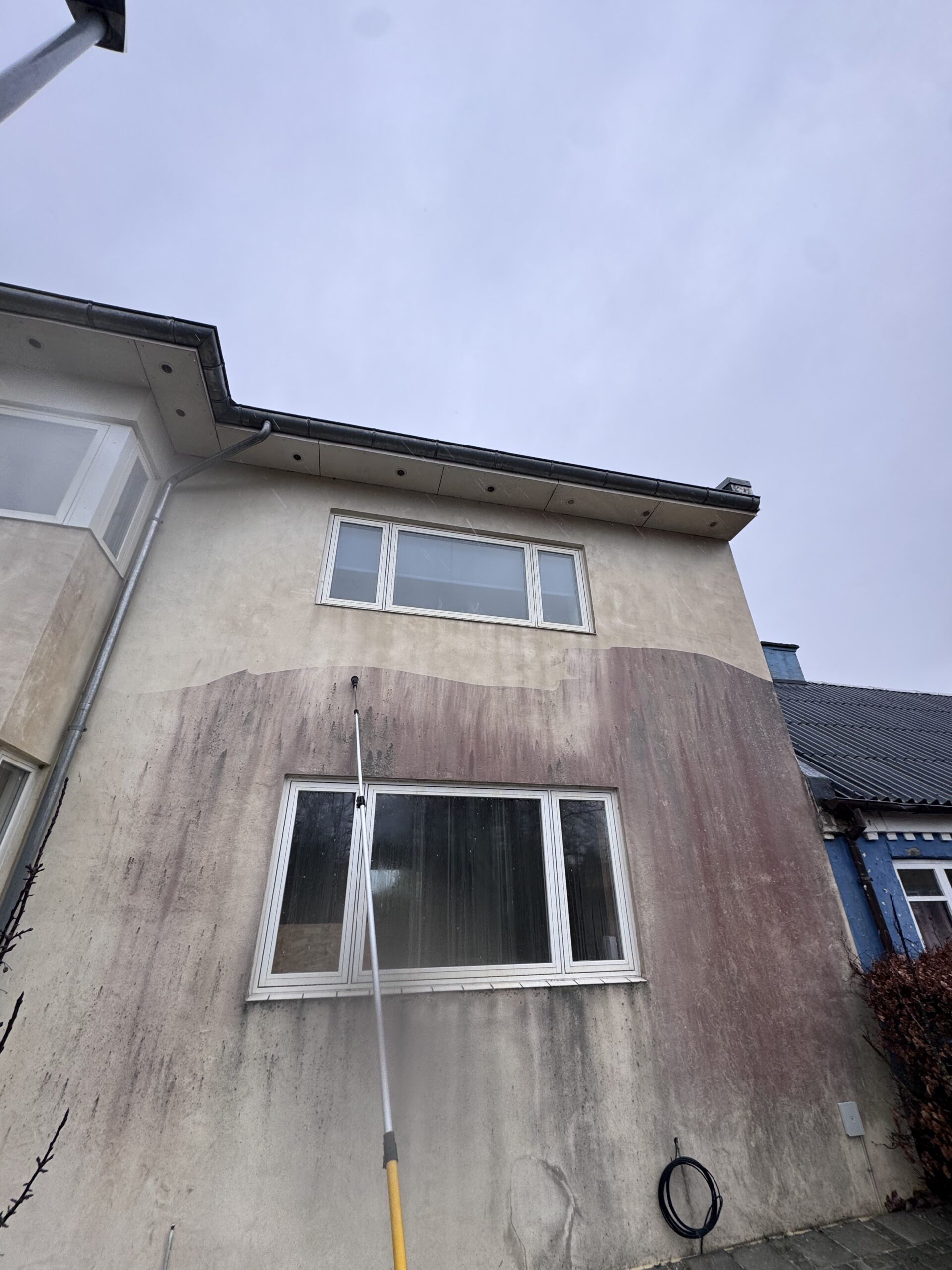 Skånsom facaderens af pudset facade med røde alger i Horsens